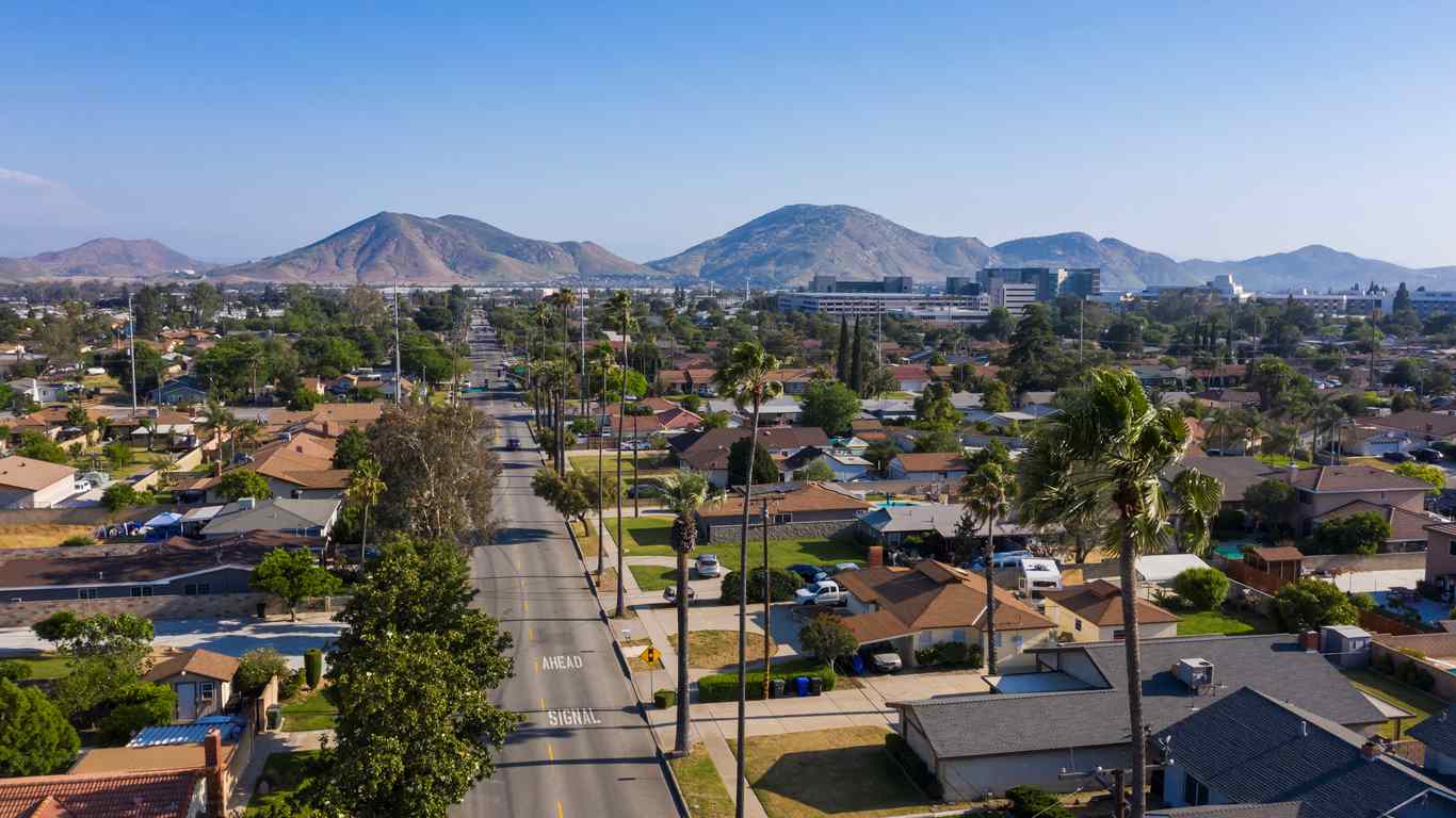 An aerial view of a residential neighborhood in Fontana, CA with mountains in the distance. 