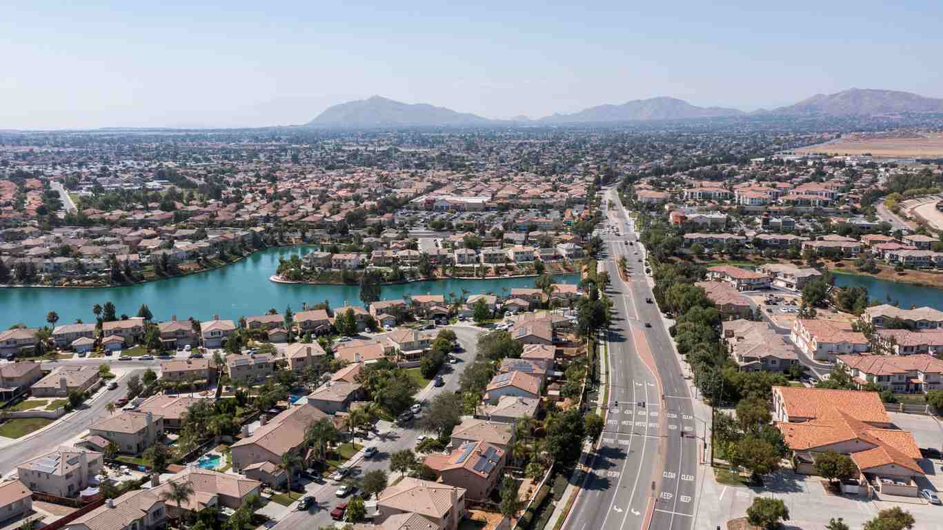 An aerial view of a residential neighborhood in Moreno Valley, CA with mountains in the distance. 